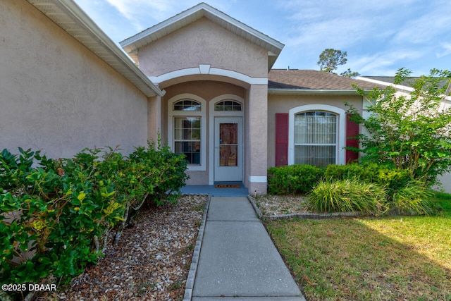 view of exterior entry featuring stucco siding