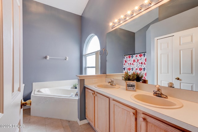 full bathroom with double vanity, tile patterned flooring, a bath, and a sink