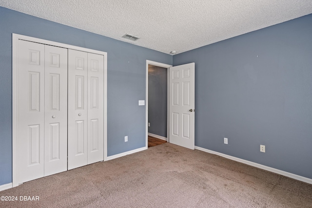 unfurnished bedroom with carpet flooring, a closet, and a textured ceiling