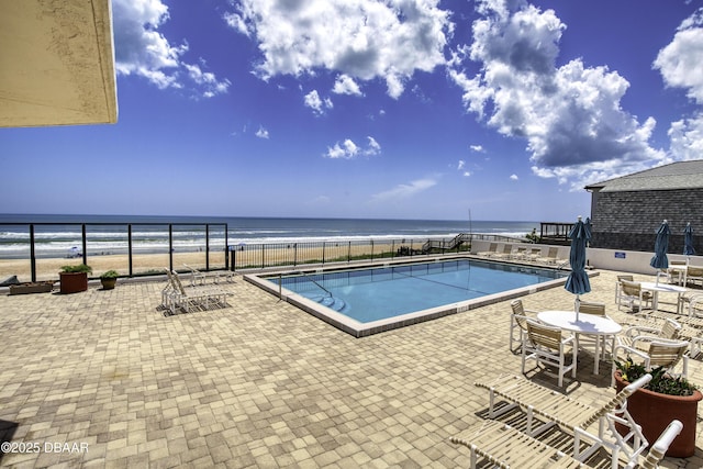 view of swimming pool featuring a water view and a patio area