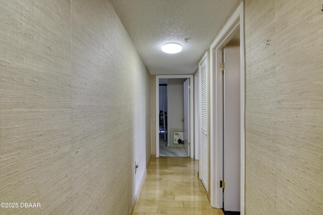 hall featuring a textured ceiling