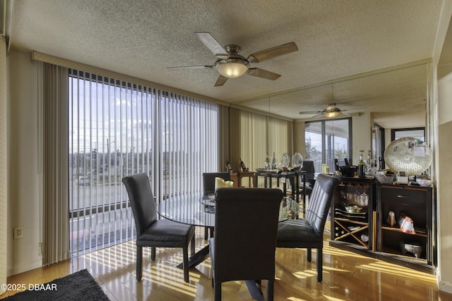 dining area featuring wood-type flooring and a textured ceiling