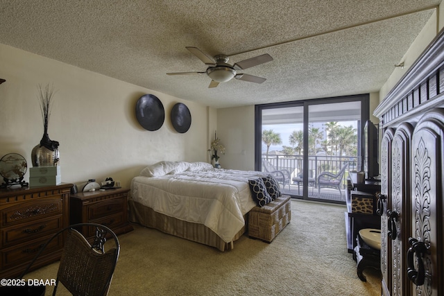 bedroom with ceiling fan, carpet flooring, access to outside, and a textured ceiling