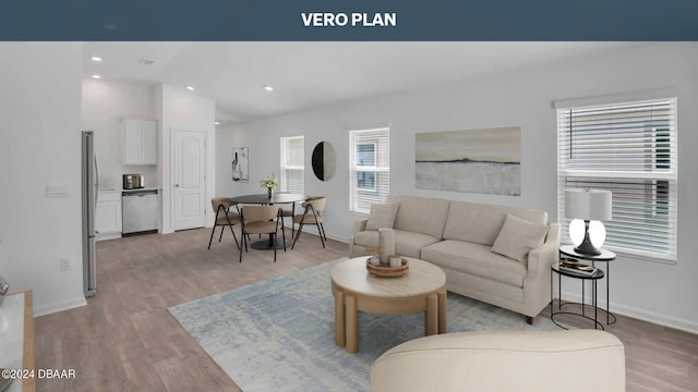 living room with light hardwood / wood-style floors and vaulted ceiling