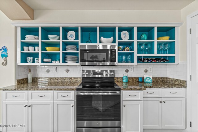 3737 S Atlantic Ave Unit 504, Daytona Beach Shores, FL 32118 - kitchen featuring open shelves, appliances with stainless steel finishes, tasteful backsplash, white cabinetry, and dark stone countertops