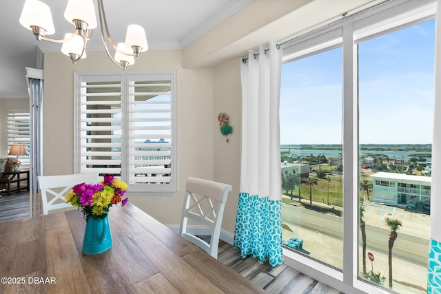 3737 S Atlantic Ave Unit 504, Daytona Beach Shores, FL 32118 - dining room featuring a chandelier, wood finished floors, crown molding, and baseboards