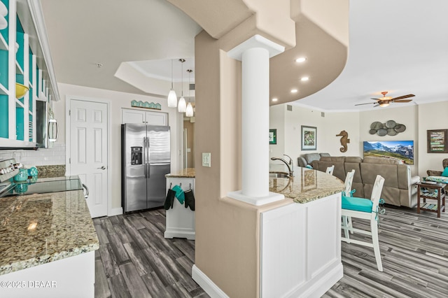 3737 S Atlantic Ave Unit 504, Daytona Beach Shores, FL 32118 - kitchen with stainless steel fridge, range with electric stovetop, dark wood-style flooring, decorative backsplash, and light stone counters