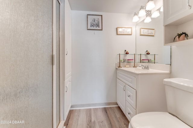 bathroom with hardwood / wood-style flooring, vanity, and toilet