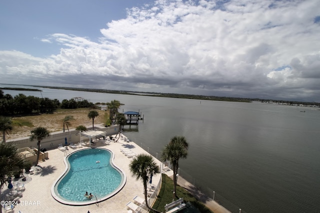 view of swimming pool with a water view and a patio area