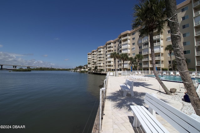 view of dock featuring a balcony, a water view, and a community pool