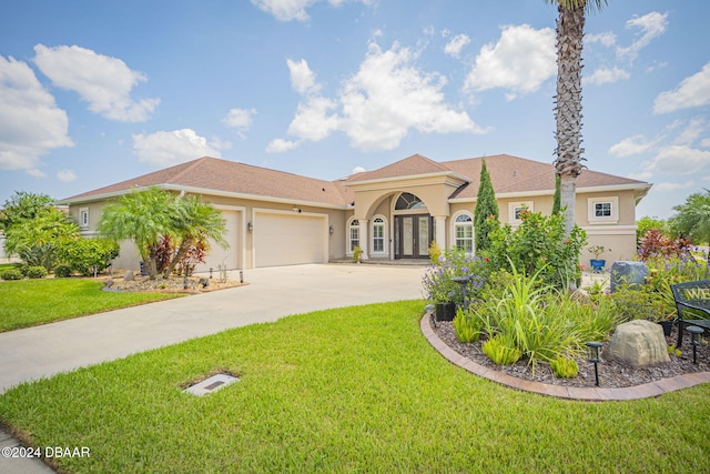 mediterranean / spanish-style home with a garage and a front lawn