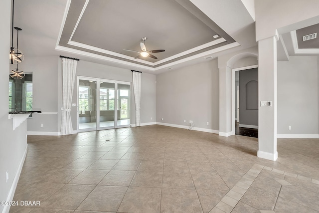 empty room featuring ceiling fan and a raised ceiling