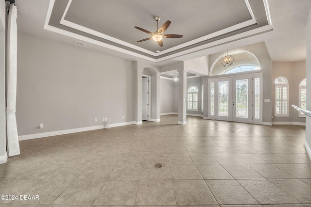 spare room with french doors, ceiling fan, a raised ceiling, and light tile patterned flooring