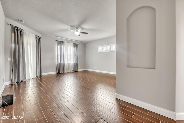 spare room with ceiling fan, dark hardwood / wood-style floors, and a textured ceiling