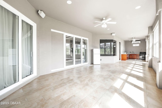 unfurnished sunroom with ceiling fan