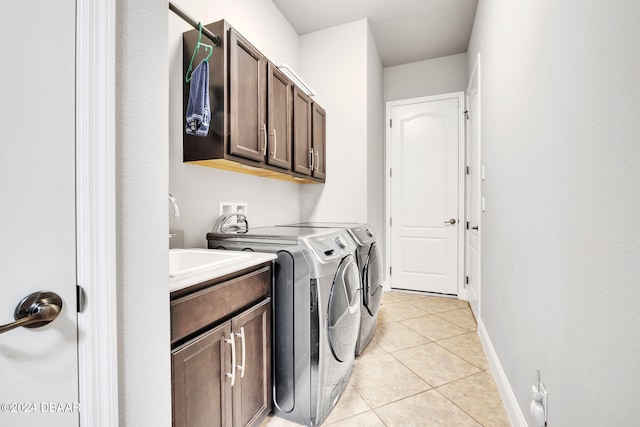 laundry room with cabinets, sink, washer and dryer, and light tile patterned floors