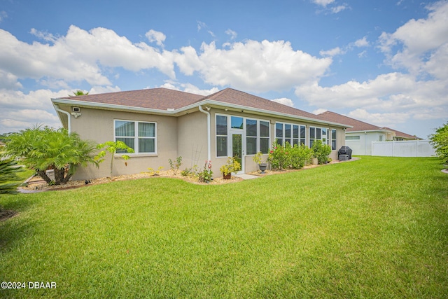 rear view of property with a lawn