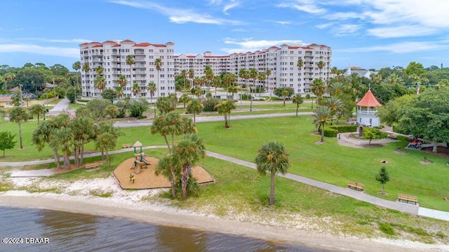 surrounding community featuring a view of the beach, a water view, and a lawn