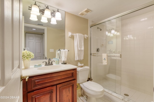 bathroom featuring tile patterned floors, vanity, toilet, and an enclosed shower