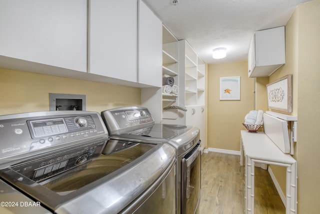 laundry room featuring light wood-type flooring, cabinets, and washer and dryer