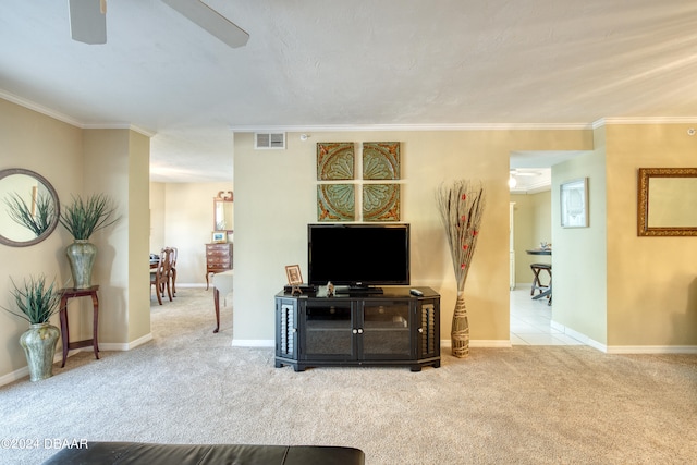 carpeted living room with ceiling fan and crown molding