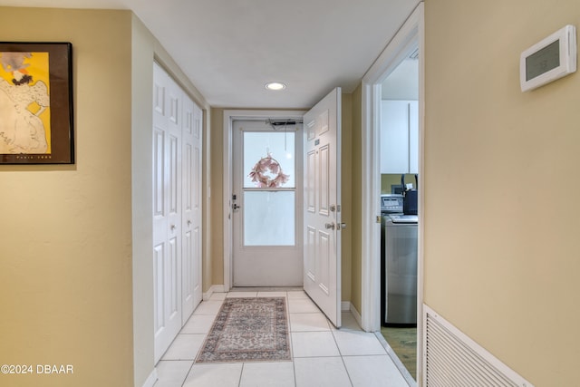 entryway with washer / dryer and light tile patterned floors