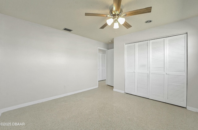 unfurnished bedroom with visible vents, a closet, speckled floor, baseboards, and ceiling fan