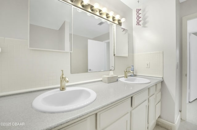 bathroom with double vanity, decorative backsplash, and a sink