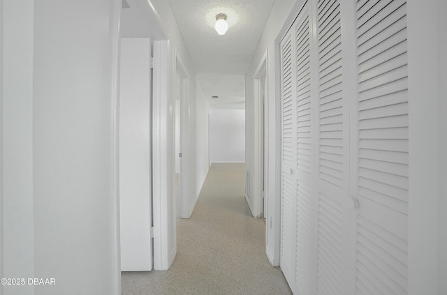 hallway with light speckled floor and a textured ceiling