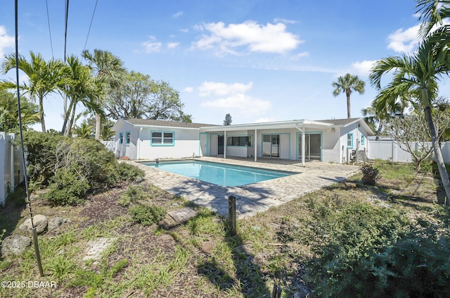 rear view of house featuring a patio area, a fenced backyard, a fenced in pool, and stucco siding