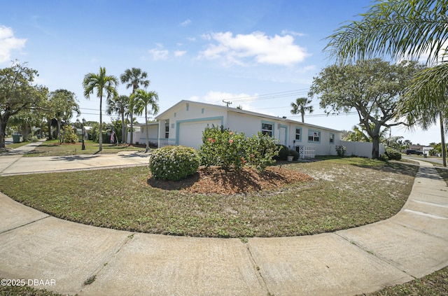 view of side of home featuring a lawn, a garage, driveway, and stucco siding