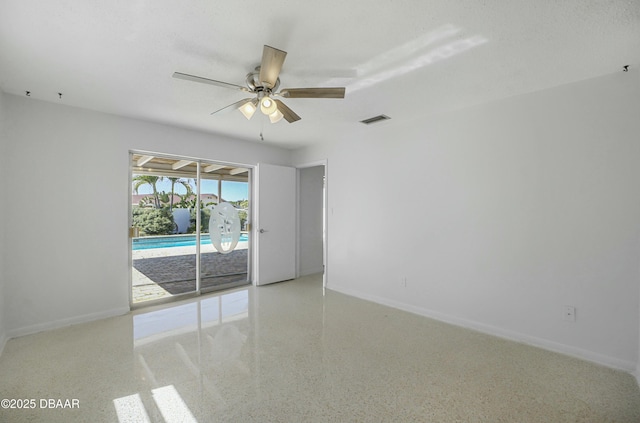 spare room with visible vents, baseboards, speckled floor, and a ceiling fan