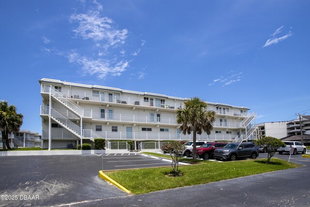 4849 Saxon Dr Unit C202, New Smyrna Beach, FL 32169 - view of apartment building / complex featuring uncovered parking and stairs