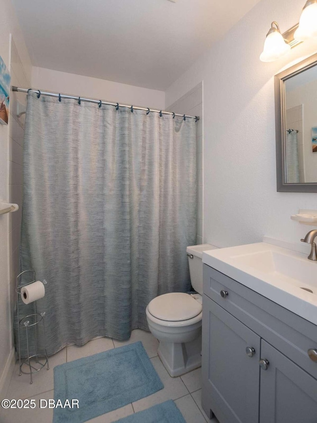 4849 Saxon Dr Unit C202, New Smyrna Beach, FL 32169 - bathroom featuring toilet, vanity, tile patterned floors, and a shower with curtain