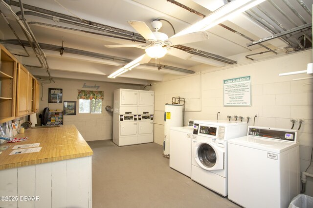 4849 Saxon Dr Unit C202, New Smyrna Beach, FL 32169 - community laundry with stacked washer / dryer, washing machine and dryer, electric water heater, concrete block wall, and a ceiling fan