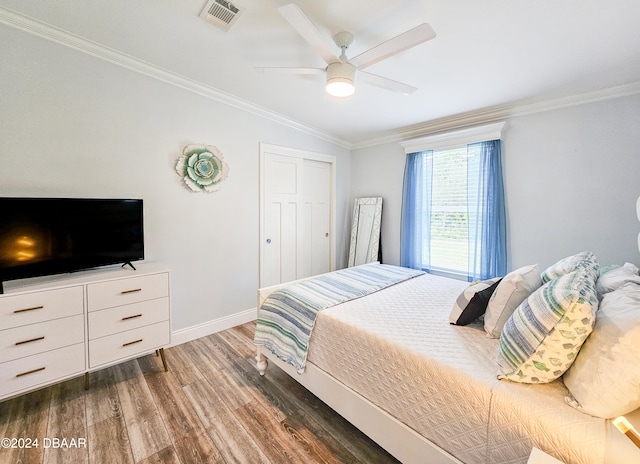 bedroom with a closet, ornamental molding, dark hardwood / wood-style flooring, lofted ceiling, and ceiling fan