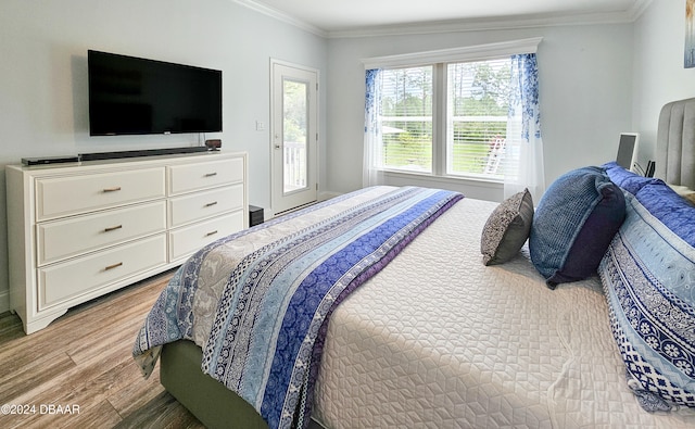 bedroom with ornamental molding, access to outside, and wood-type flooring