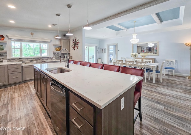 kitchen with sink, a kitchen bar, dark hardwood / wood-style floors, dishwasher, and decorative backsplash