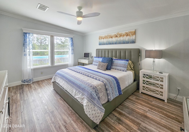 bedroom featuring ceiling fan, dark hardwood / wood-style floors, vaulted ceiling, and ornamental molding