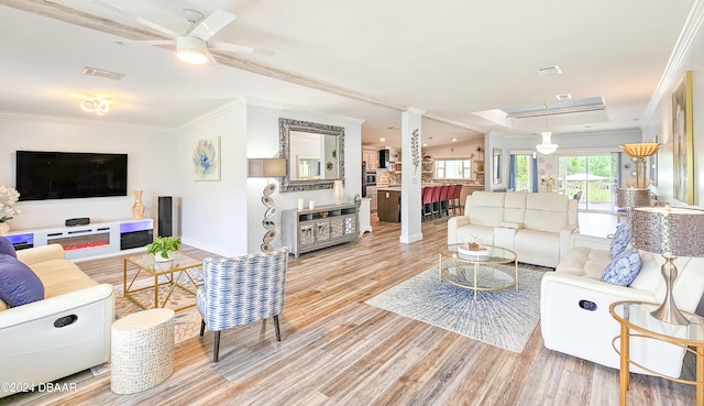 living room with ornamental molding, hardwood / wood-style flooring, and ceiling fan