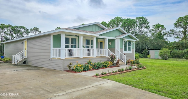 view of front of property with a storage shed, a porch, and a front yard