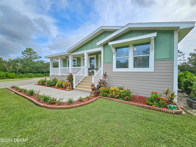 view of front of home with covered porch and a front yard