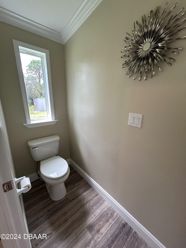 bathroom with toilet, hardwood / wood-style flooring, and ornamental molding