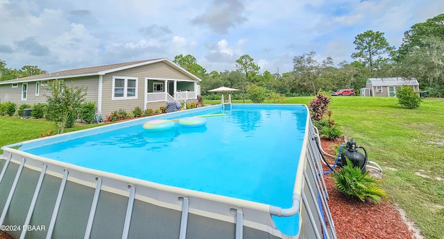 view of swimming pool featuring a lawn and an outdoor structure