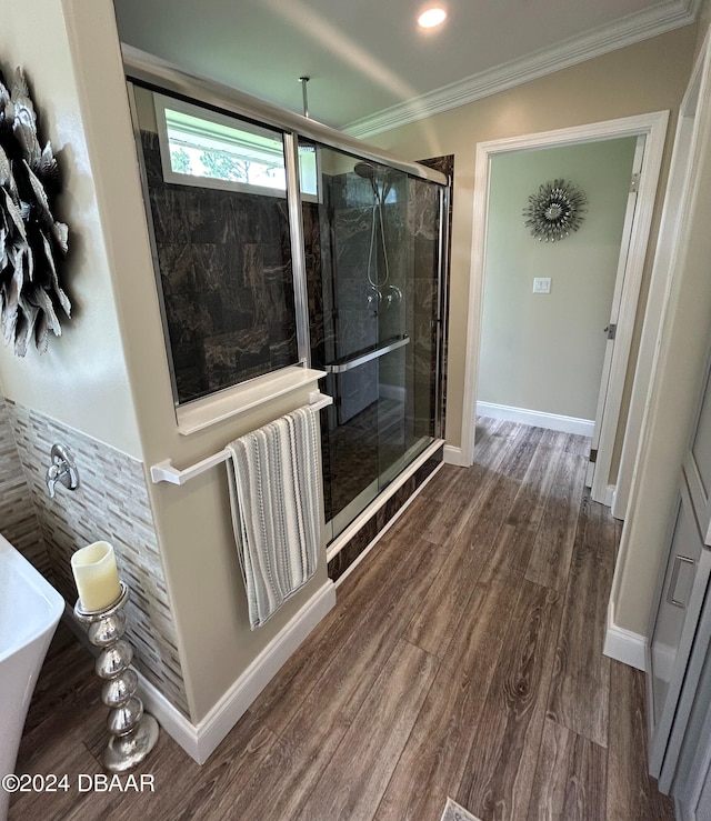 bathroom featuring ornamental molding, hardwood / wood-style flooring, and separate shower and tub