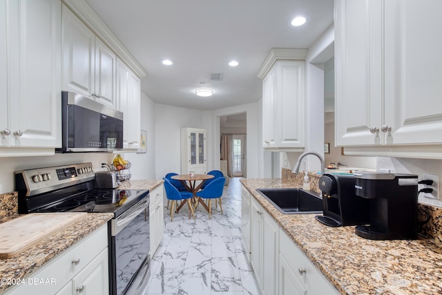 kitchen featuring white cabinets, sink, light stone countertops, and stainless steel appliances