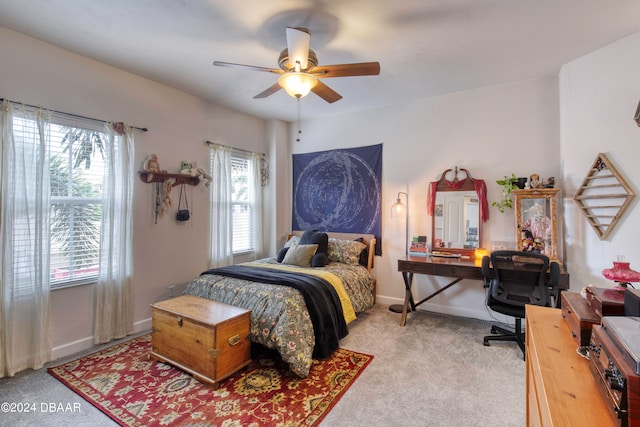 carpeted bedroom with ceiling fan and multiple windows