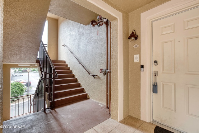 tiled foyer entrance with a textured ceiling