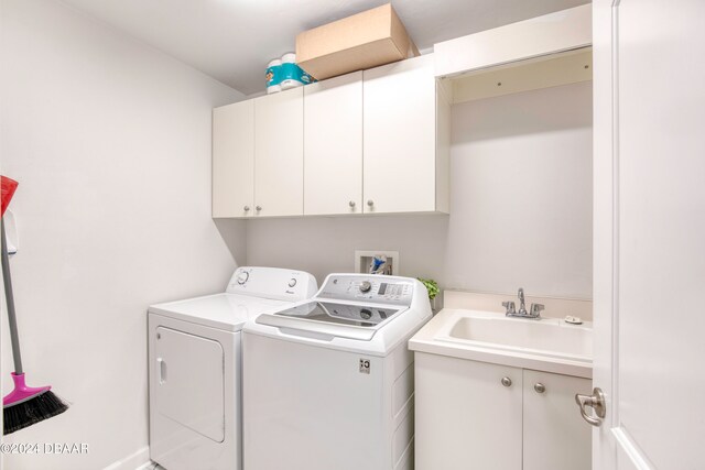 laundry room featuring cabinets, washing machine and dryer, and sink