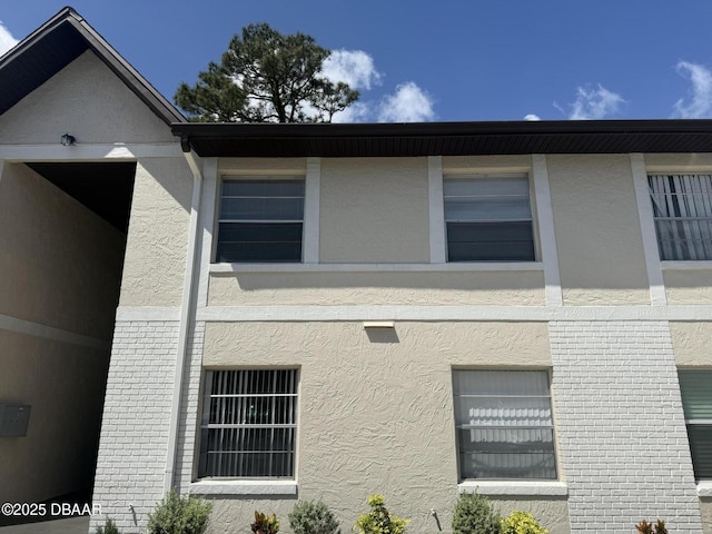 view of property exterior featuring brick siding and stucco siding